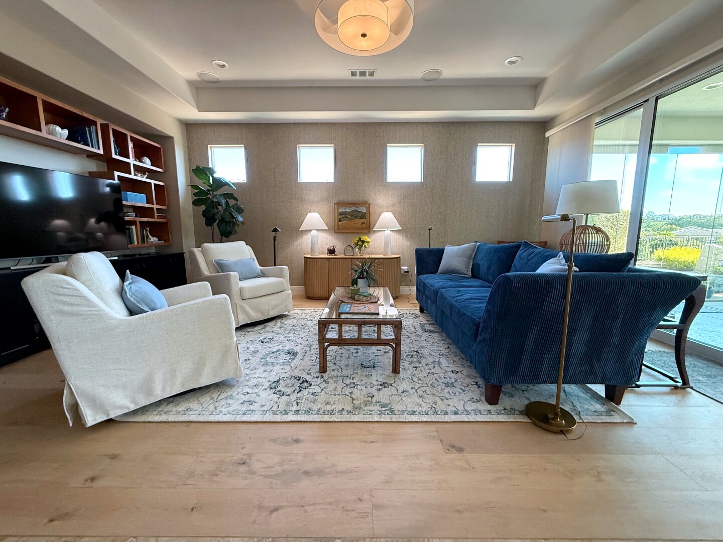 Great room with navy sofa, slipcovered chairs, and a warm layered rug