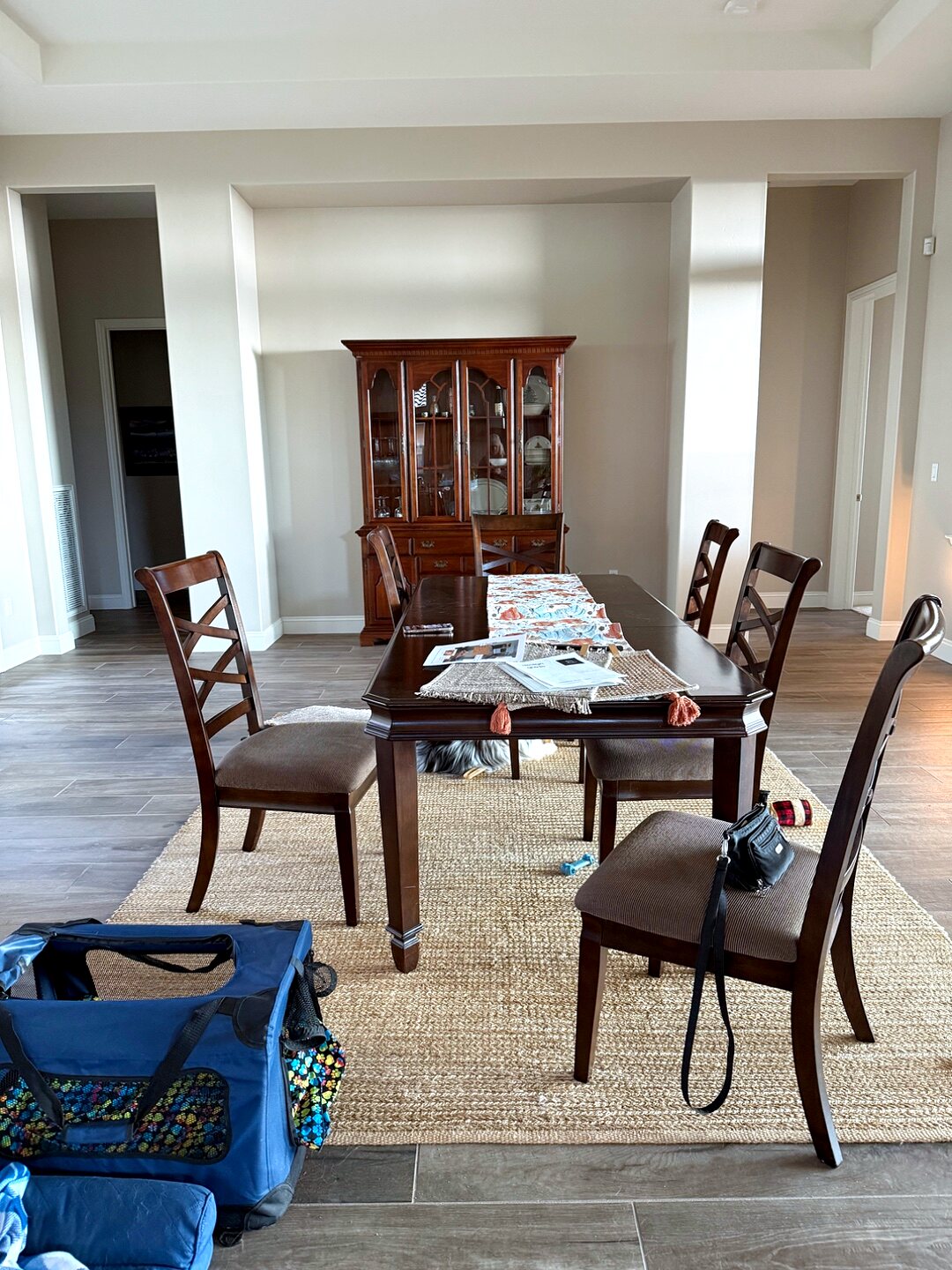 Dining room before — plain beige walls, a dark wood table, and bare surfaces