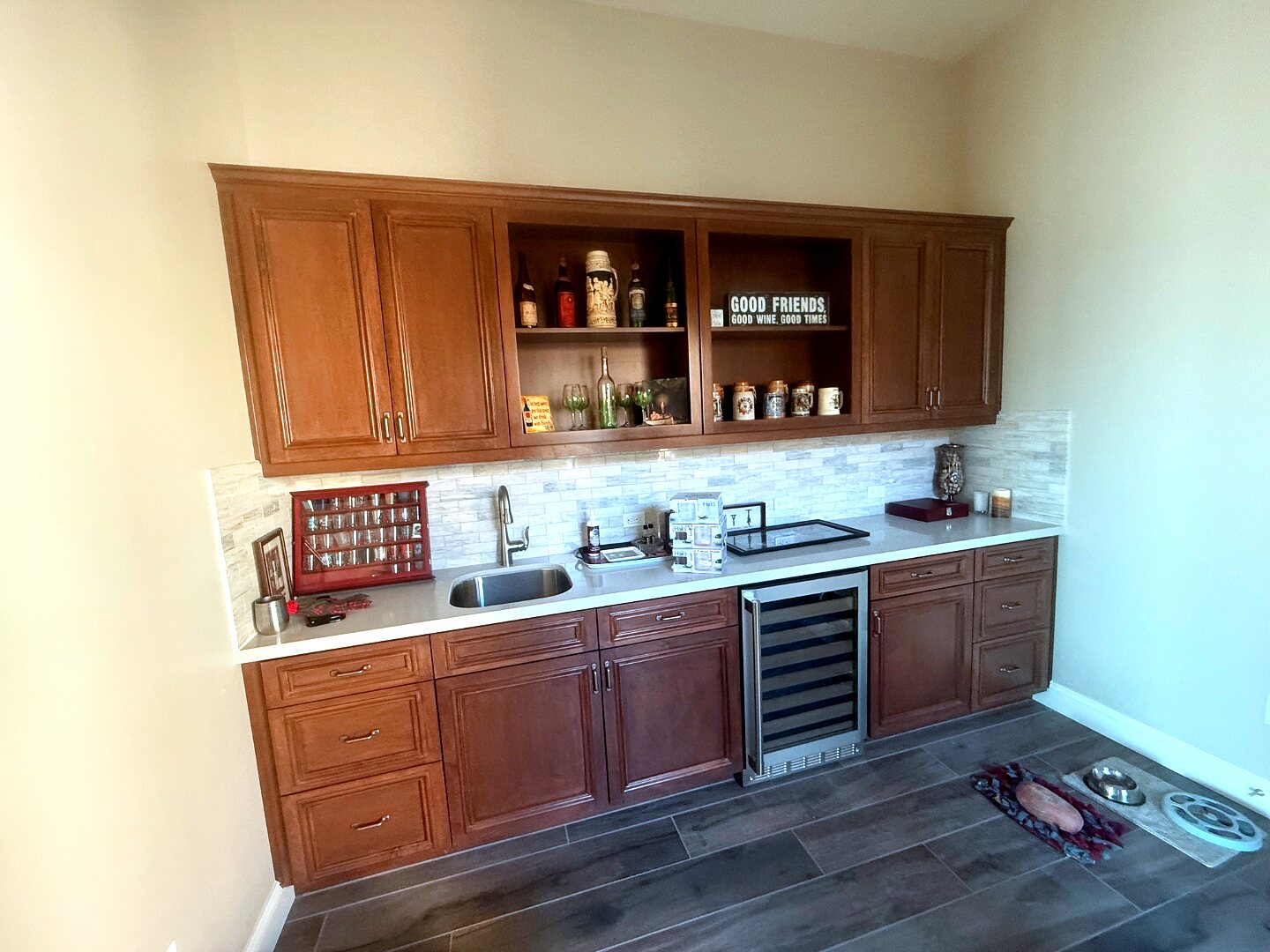 Wine room before — a builder-grade wet bar with brown cabinetry and plain beige walls